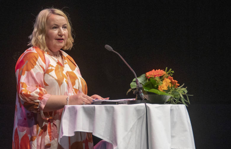 KUUMA-johtokunnan puheenjohtaja Anne Karjalainen puhumassa yleisölle